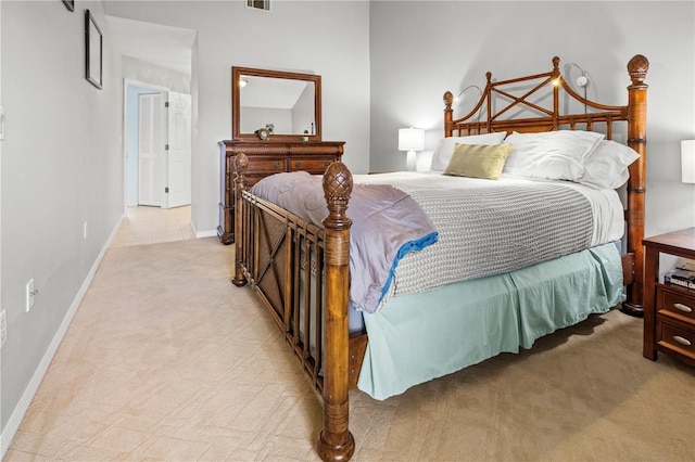 bedroom with baseboards, visible vents, and light carpet