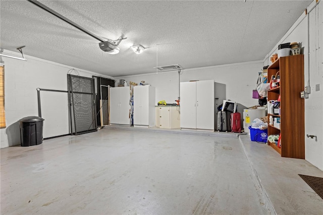 garage with visible vents, a garage door opener, and concrete block wall