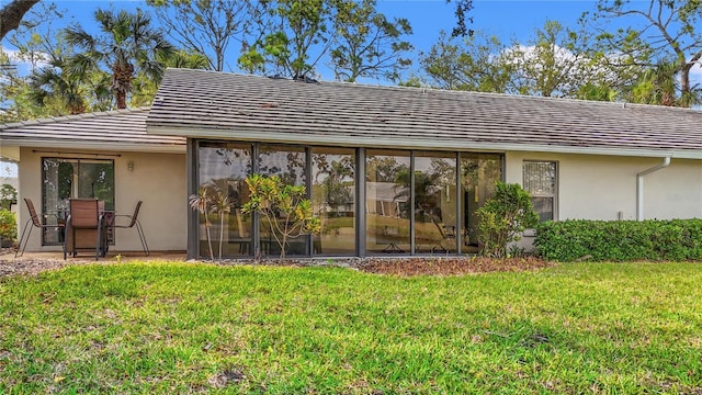 rear view of house with a yard and stucco siding