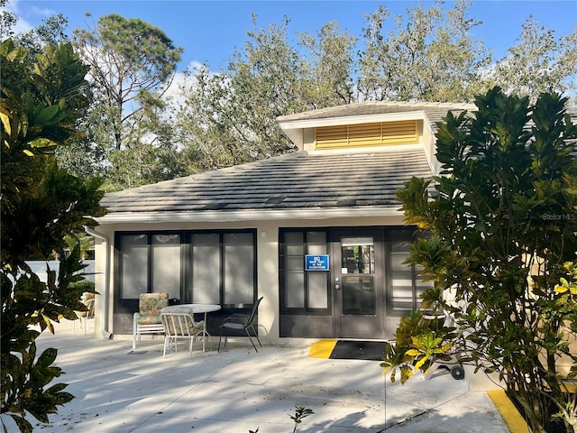 rear view of house featuring a patio area and stucco siding