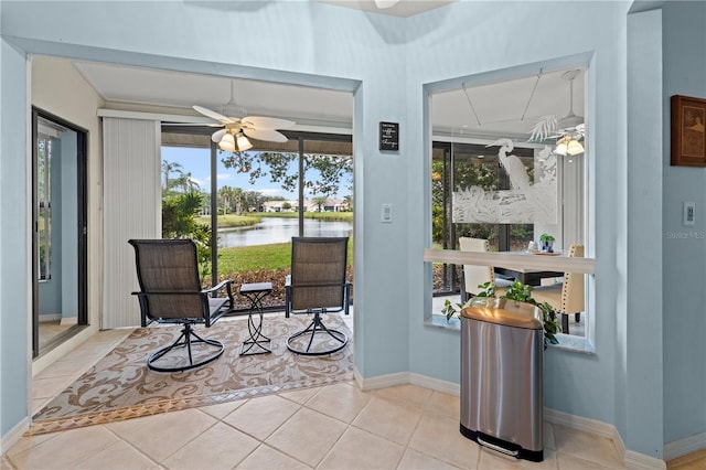 sitting room with tile patterned floors, baseboards, a water view, and ceiling fan