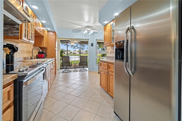 kitchen featuring a sink, stainless steel appliances, light countertops, light tile patterned floors, and ceiling fan