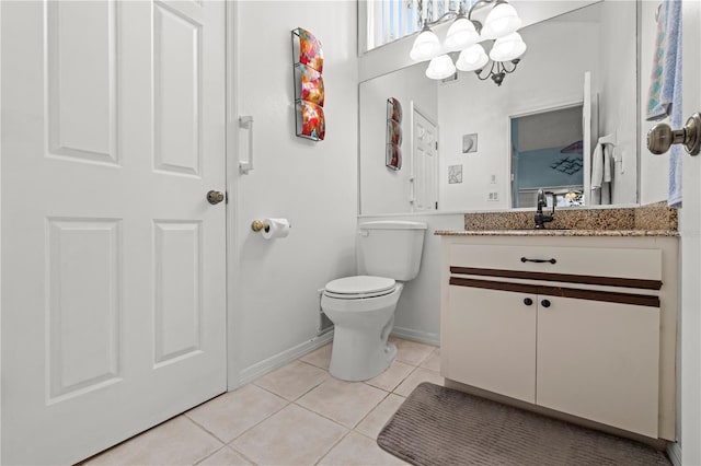 bathroom featuring toilet, tile patterned flooring, baseboards, a chandelier, and vanity