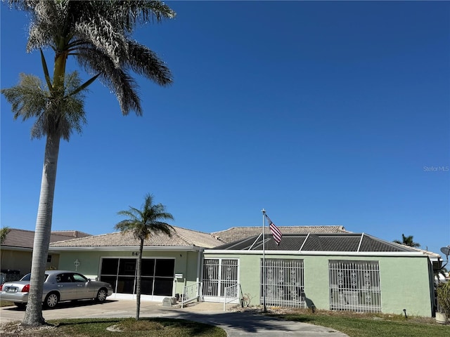 view of front facade with an attached garage, driveway, and stucco siding