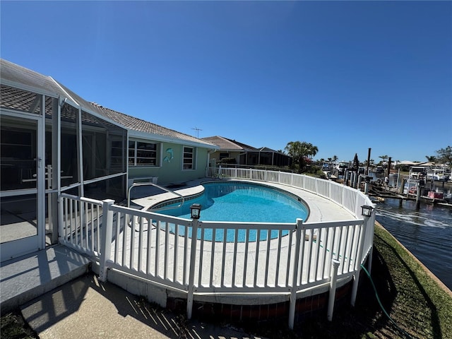 view of pool with fence, a fenced in pool, a water view, a lanai, and a patio area