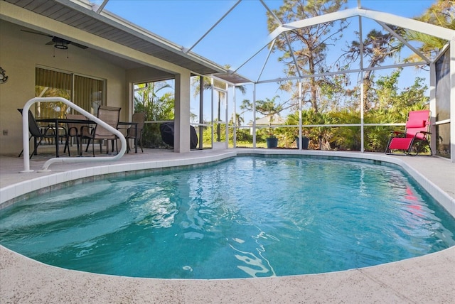 outdoor pool with a lanai, a patio area, and ceiling fan