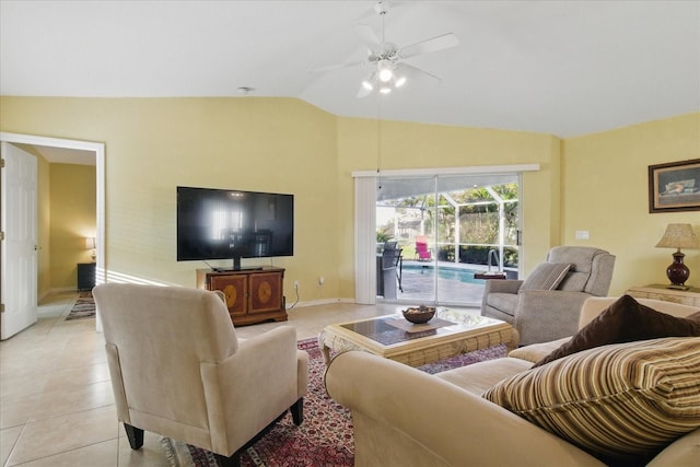 living area with baseboards, lofted ceiling, light tile patterned flooring, and a ceiling fan