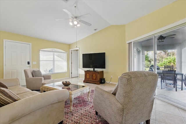 living area featuring lofted ceiling, light tile patterned flooring, a ceiling fan, and baseboards