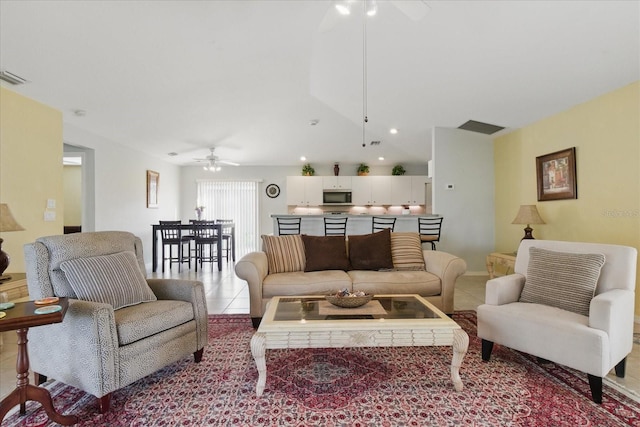 living room featuring light tile patterned floors, visible vents, and a ceiling fan