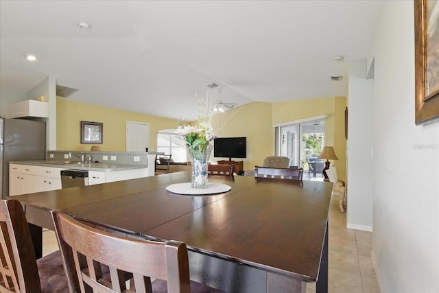 dining space with visible vents, baseboards, ceiling fan, vaulted ceiling, and light tile patterned floors