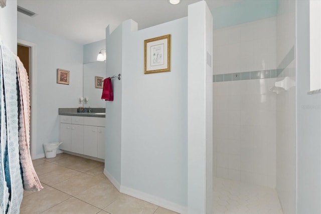 full bath with tile patterned flooring, visible vents, baseboards, walk in shower, and vanity