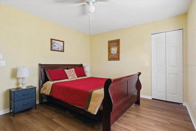 bedroom featuring a closet, baseboards, wood finished floors, and a ceiling fan