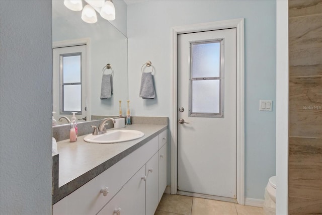 bathroom featuring plenty of natural light, toilet, vanity, and tile patterned flooring