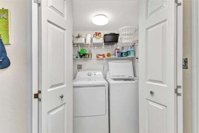 clothes washing area featuring laundry area and washer and clothes dryer