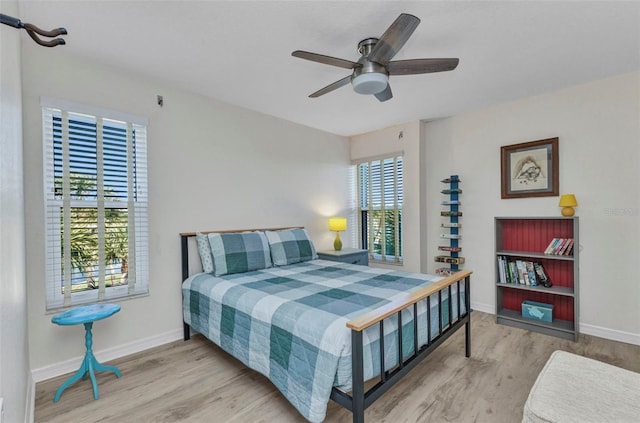 bedroom featuring ceiling fan, baseboards, and wood finished floors