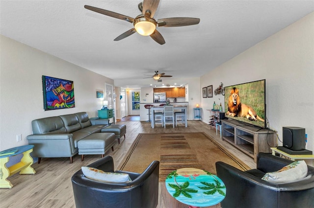 living room with light wood-style flooring and ceiling fan