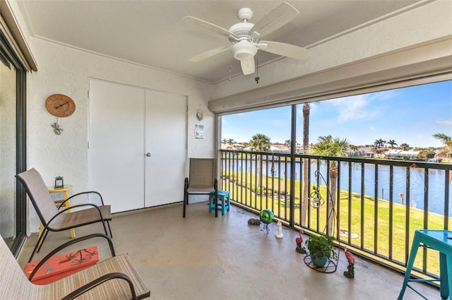 sunroom featuring a water view and ceiling fan