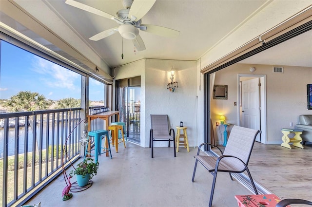 sunroom / solarium with visible vents, a water view, and ceiling fan