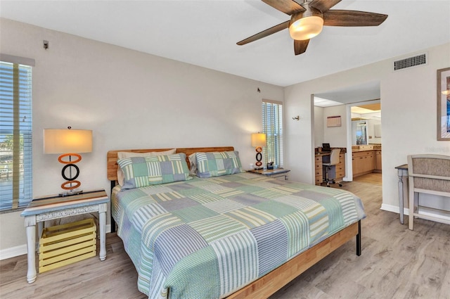 bedroom with wood finished floors, visible vents, and baseboards