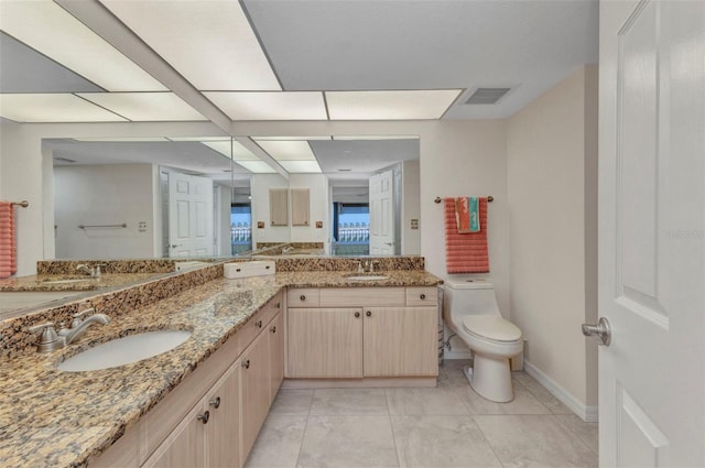 bathroom with double vanity, toilet, visible vents, and a sink