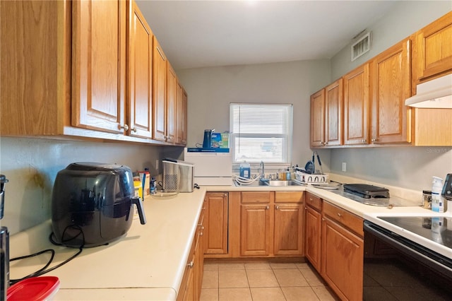 kitchen with light tile patterned floors, visible vents, a sink, light countertops, and range with electric stovetop