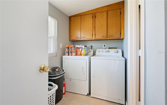 laundry area with light tile patterned floors, cabinet space, and washing machine and dryer