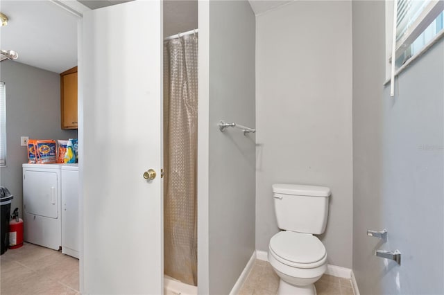 bathroom featuring tile patterned floors, toilet, a shower stall, baseboards, and washing machine and clothes dryer