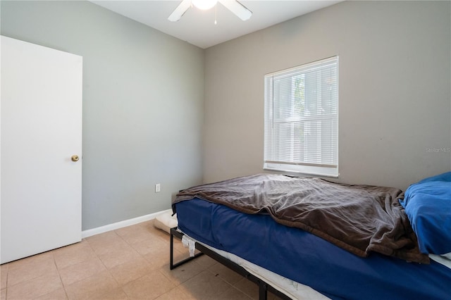 bedroom featuring light tile patterned floors, a ceiling fan, and baseboards