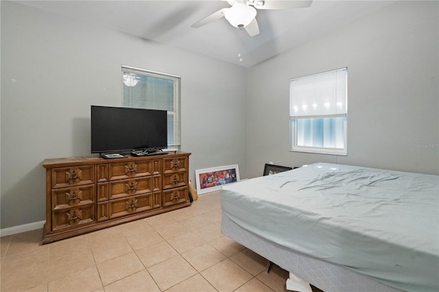 bedroom with lofted ceiling, light tile patterned floors, baseboards, and ceiling fan