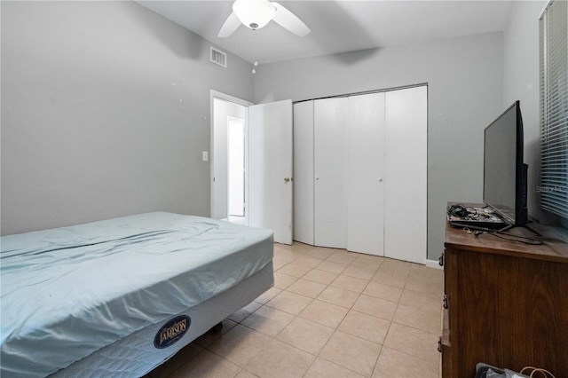 bedroom with light tile patterned floors, visible vents, a closet, and a ceiling fan