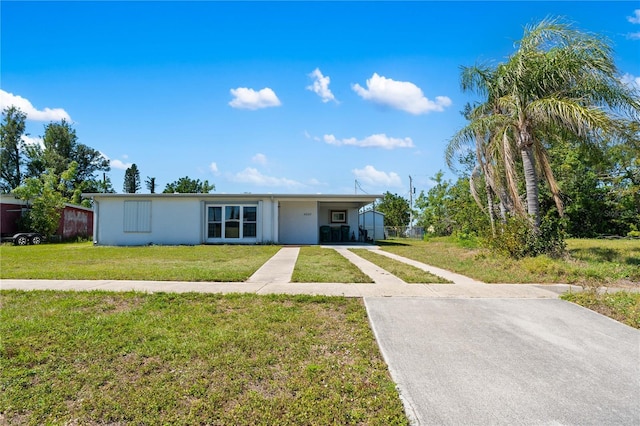 single story home with an attached carport, concrete driveway, a front yard, and stucco siding