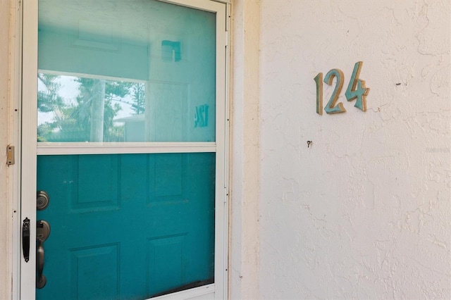 entrance to property featuring stucco siding