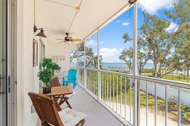 balcony with a water view and a ceiling fan