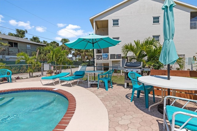 view of pool featuring a fenced in pool, a patio area, fence, and a grill