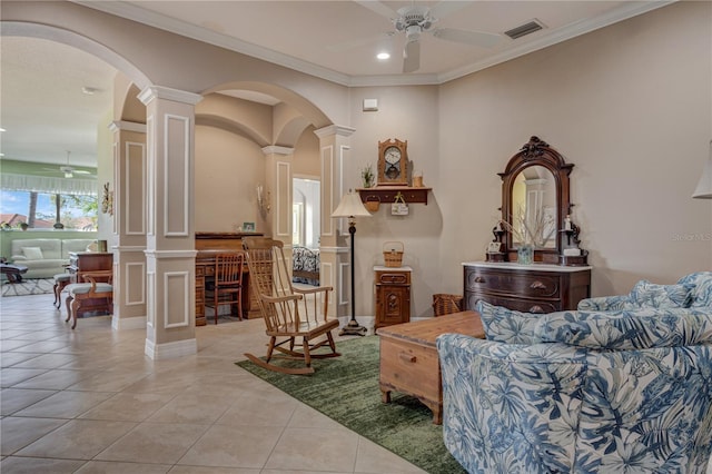 living area with light tile patterned floors, a ceiling fan, visible vents, ornate columns, and arched walkways