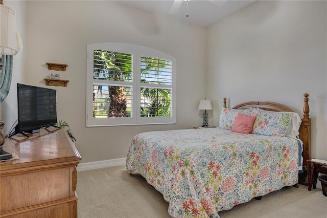 bedroom with ceiling fan, baseboards, and light carpet