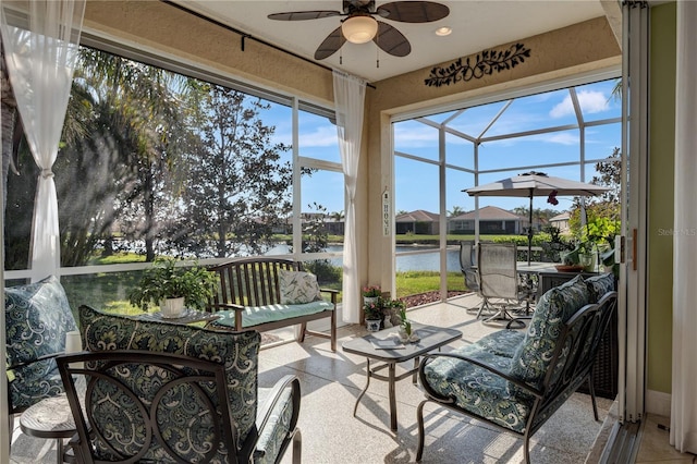 sunroom with a water view and ceiling fan