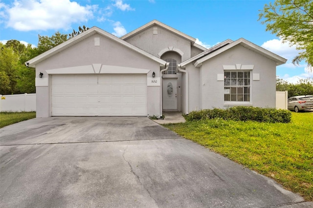 view of front of property featuring stucco siding, an attached garage, concrete driveway, and fence