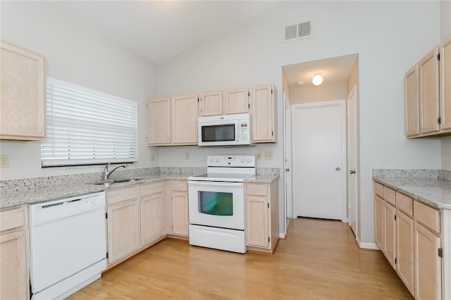 kitchen with visible vents, light brown cabinets, light wood-type flooring, lofted ceiling, and white appliances