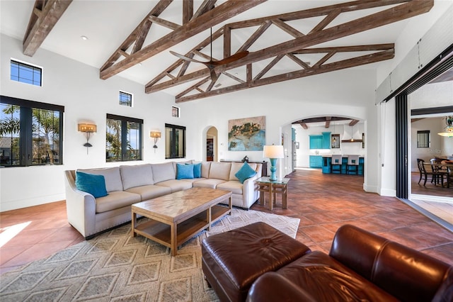 1111 San Mateo Dr, Punta Gorda, FL 33950 - living room featuring tile patterned floors, beamed ceiling, arched walkways, and high vaulted ceiling