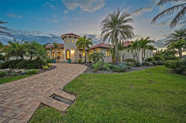 1111 San Mateo Dr, Punta Gorda, FL 33950 - mediterranean / spanish-style home featuring a tile roof, decorative driveway, a front lawn, and stucco siding