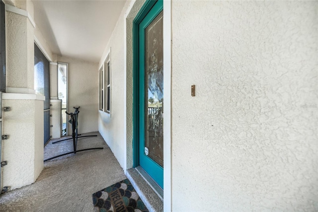 property entrance with stucco siding and a balcony