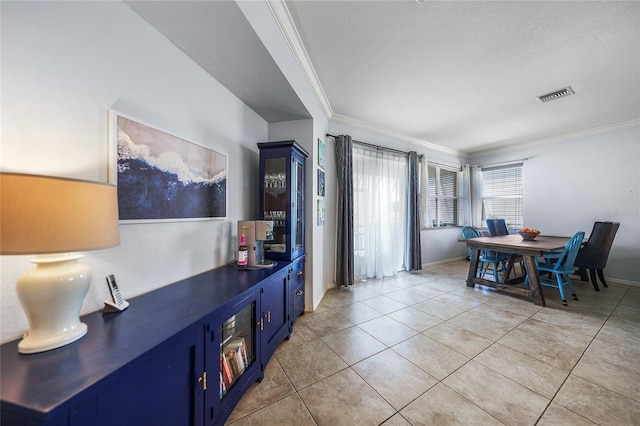 dining area featuring light tile patterned floors, visible vents, baseboards, and ornamental molding