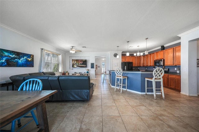 living area with crown molding, light tile patterned flooring, a ceiling fan, and baseboards