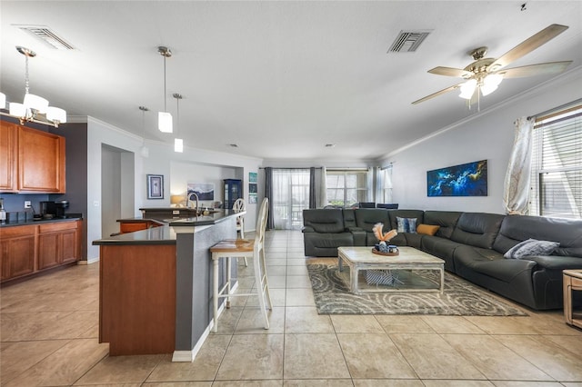 living room with light tile patterned floors, visible vents, crown molding, and ceiling fan with notable chandelier