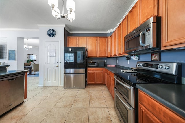 kitchen featuring dark countertops, a chandelier, brown cabinets, light tile patterned flooring, and stainless steel appliances