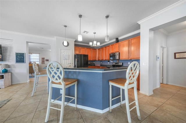 kitchen with dark countertops, visible vents, appliances with stainless steel finishes, and a breakfast bar area