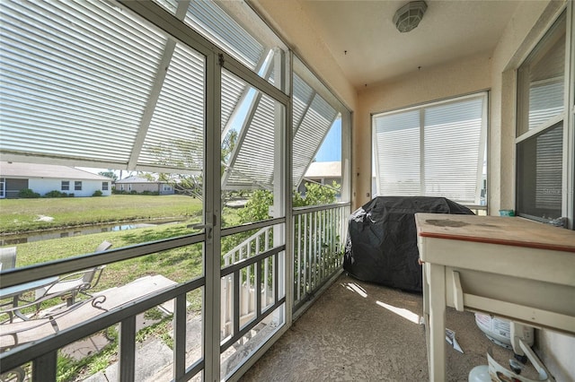 sunroom / solarium featuring a water view