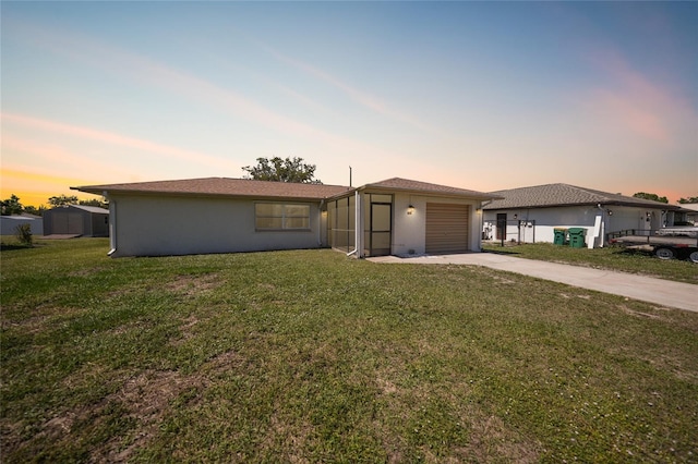 view of front of home featuring a front lawn, a garage, driveway, and stucco siding