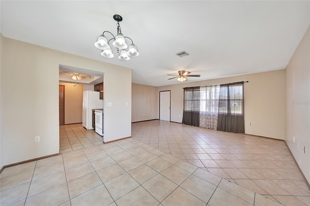 spare room with light tile patterned floors, visible vents, ceiling fan with notable chandelier, and baseboards